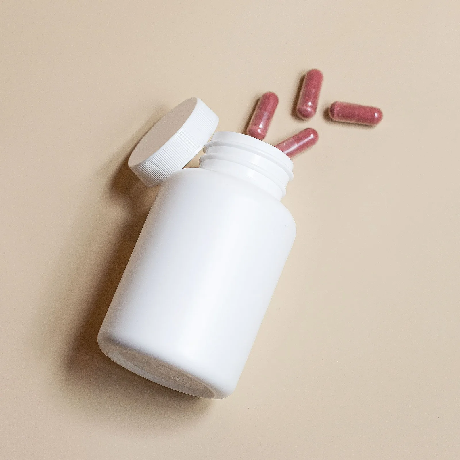 Open white bottle with capsules