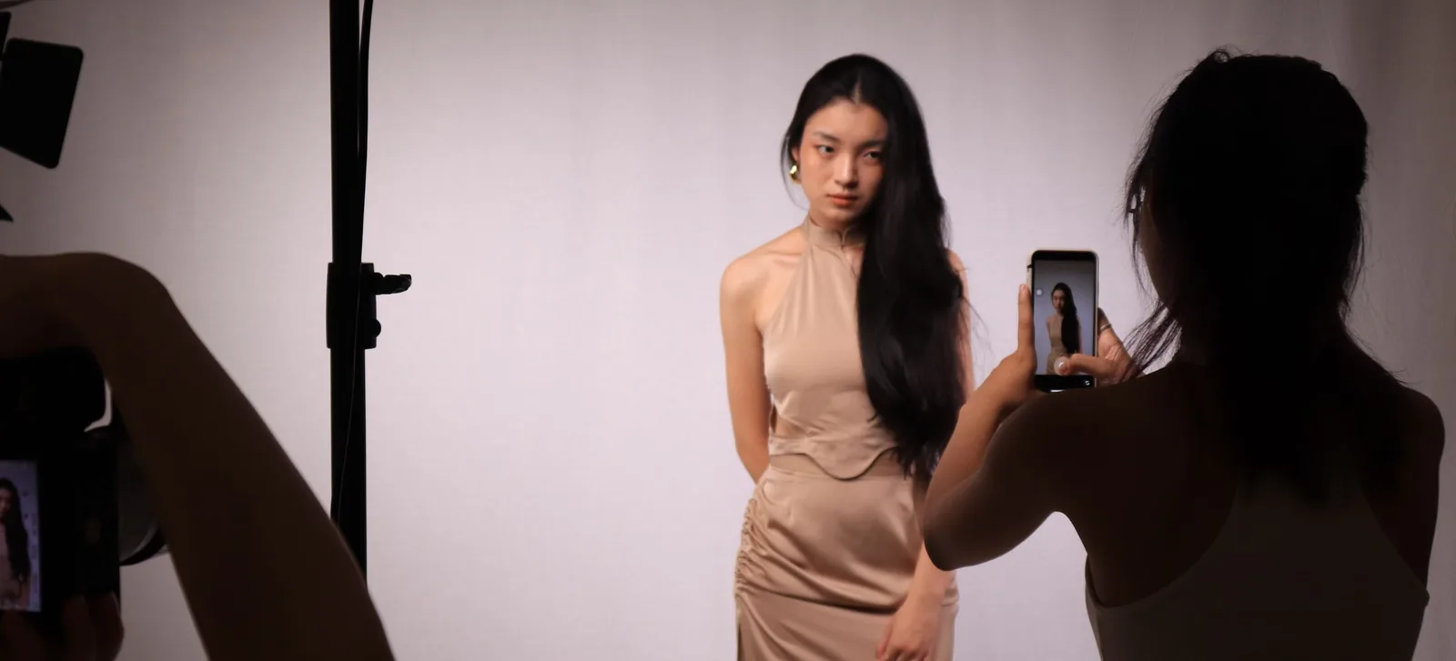 A model in a beige dress in the studio