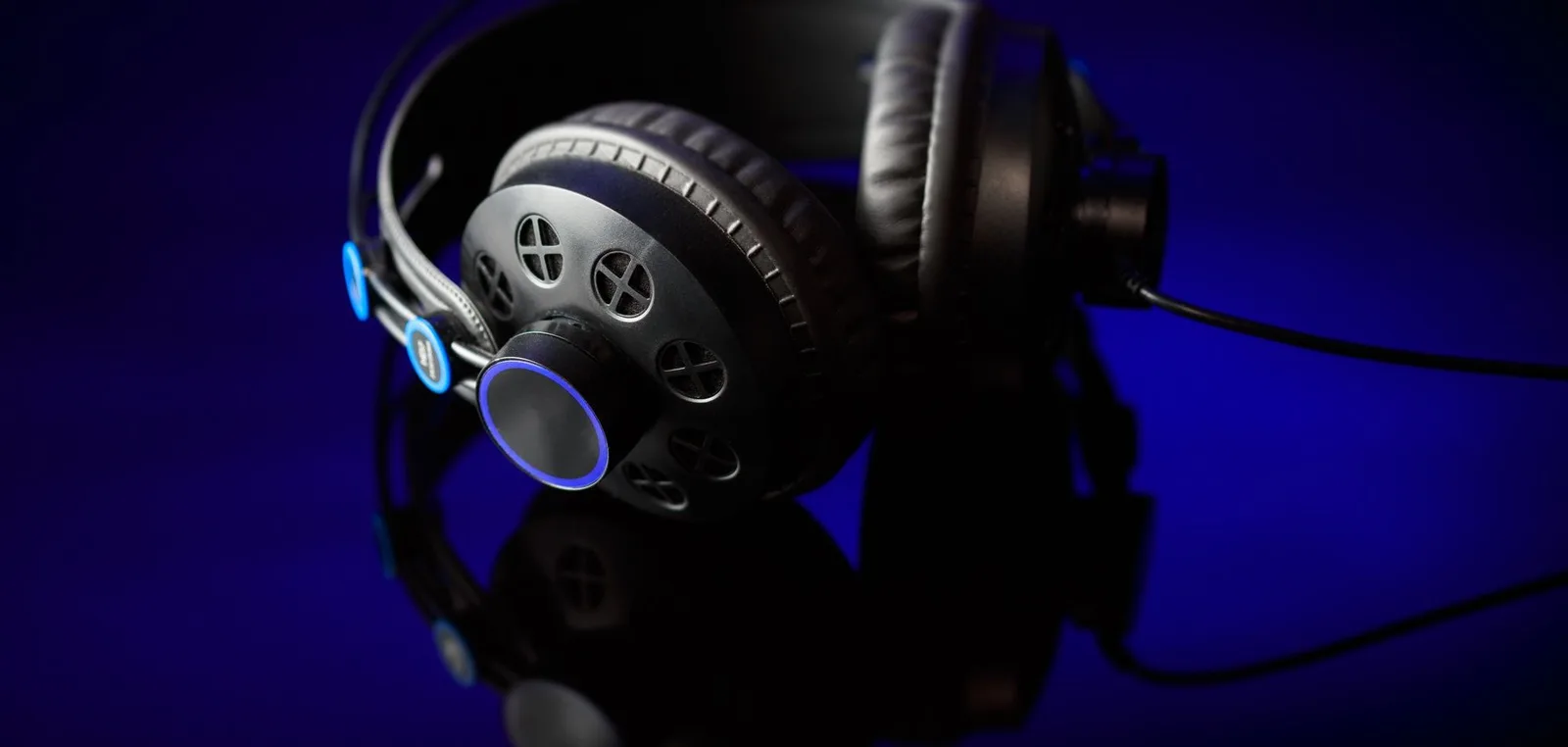 Headphones lit in blue on a dark table
