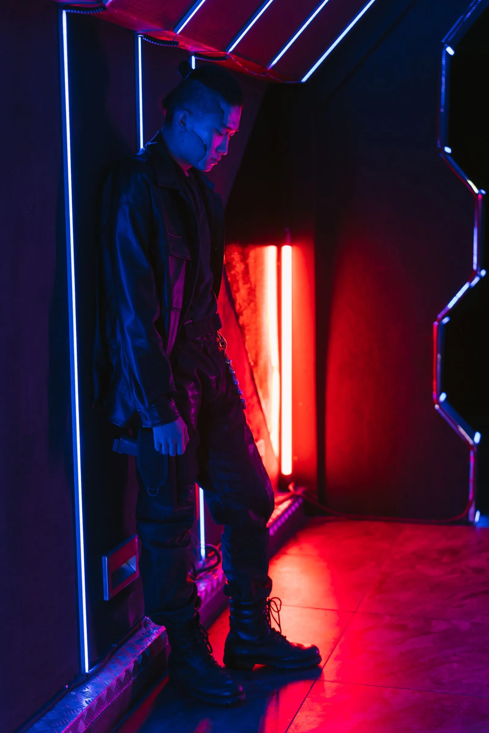 A black field jacket under red and blue neon