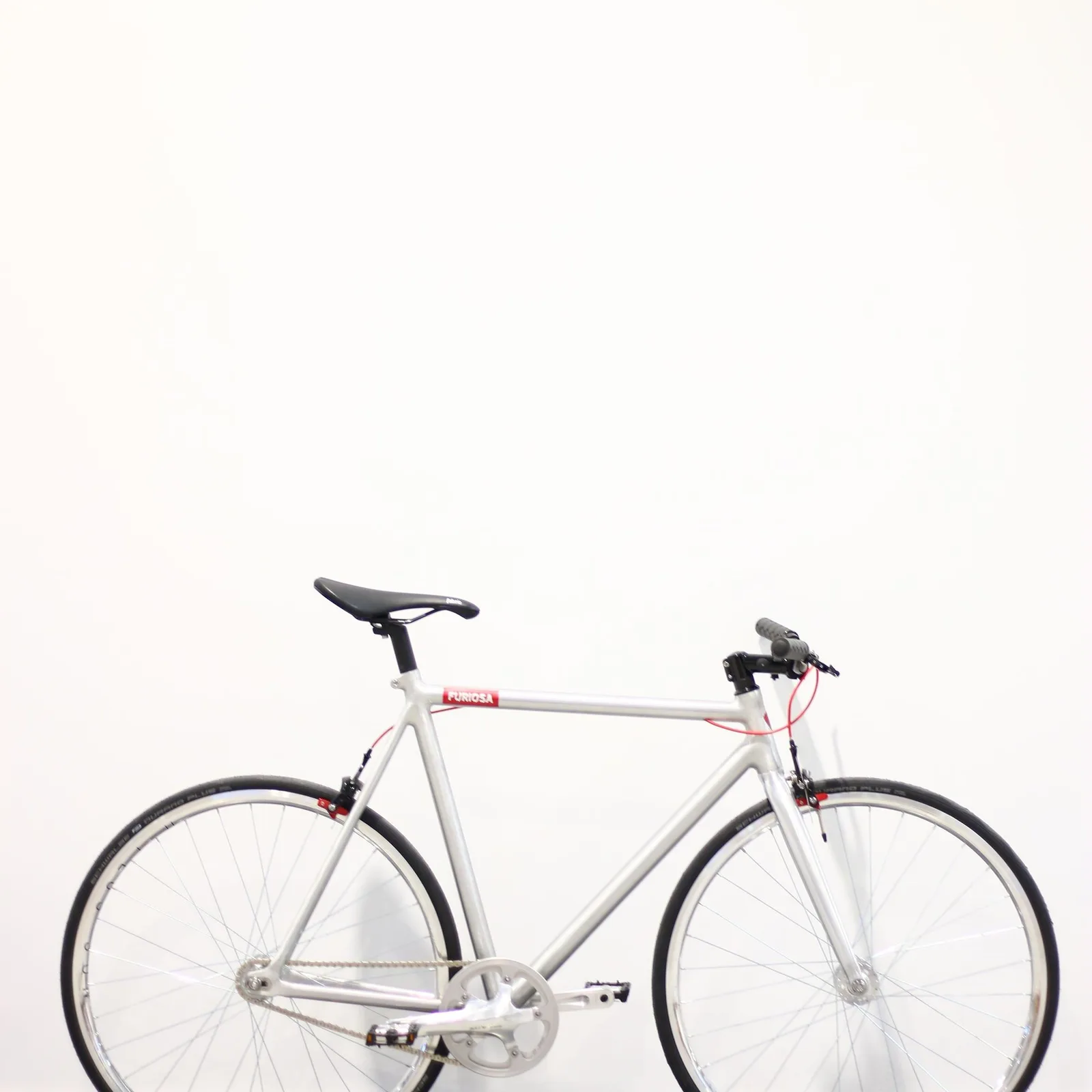 Silver bike against a white wall