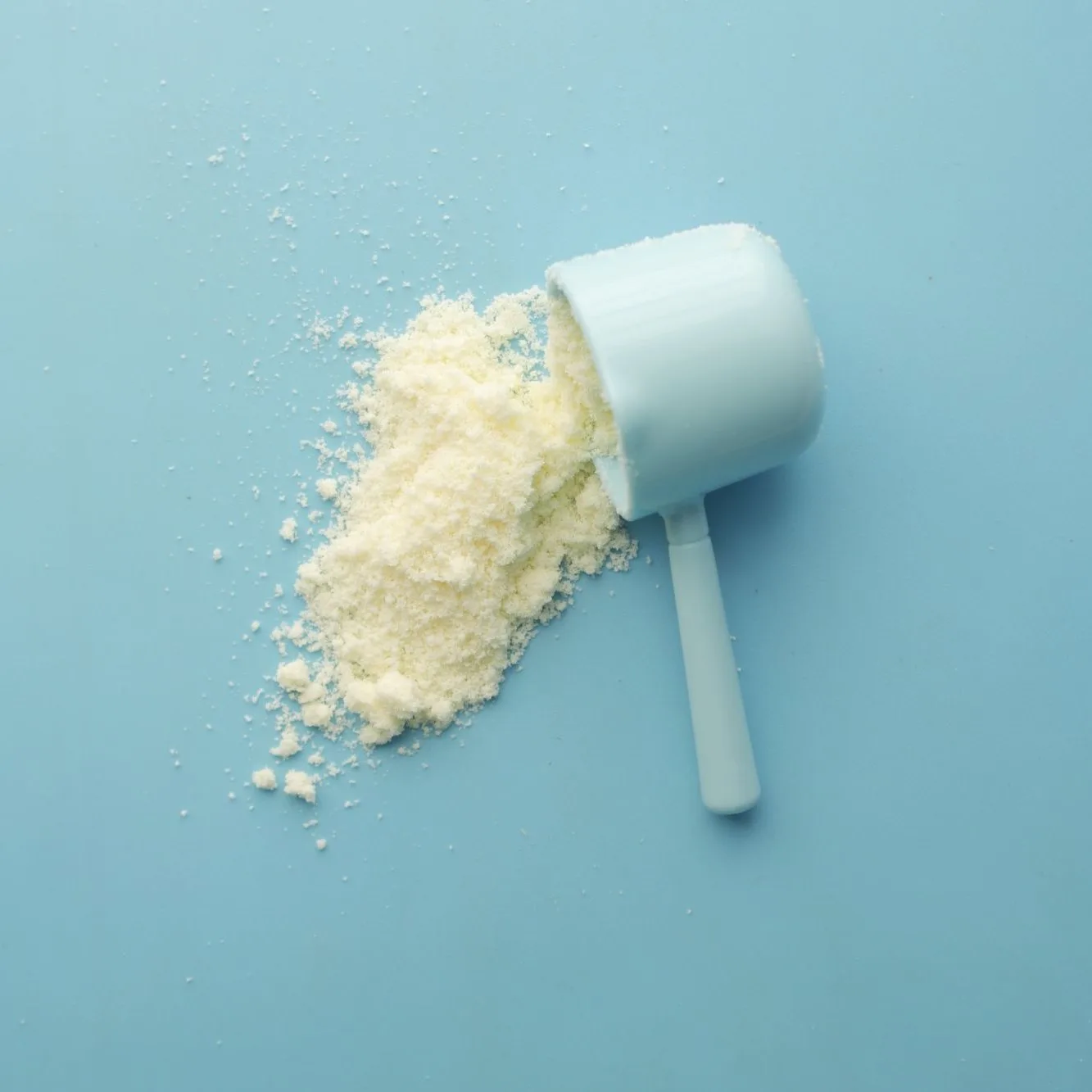 A scoop of powder on pale blue