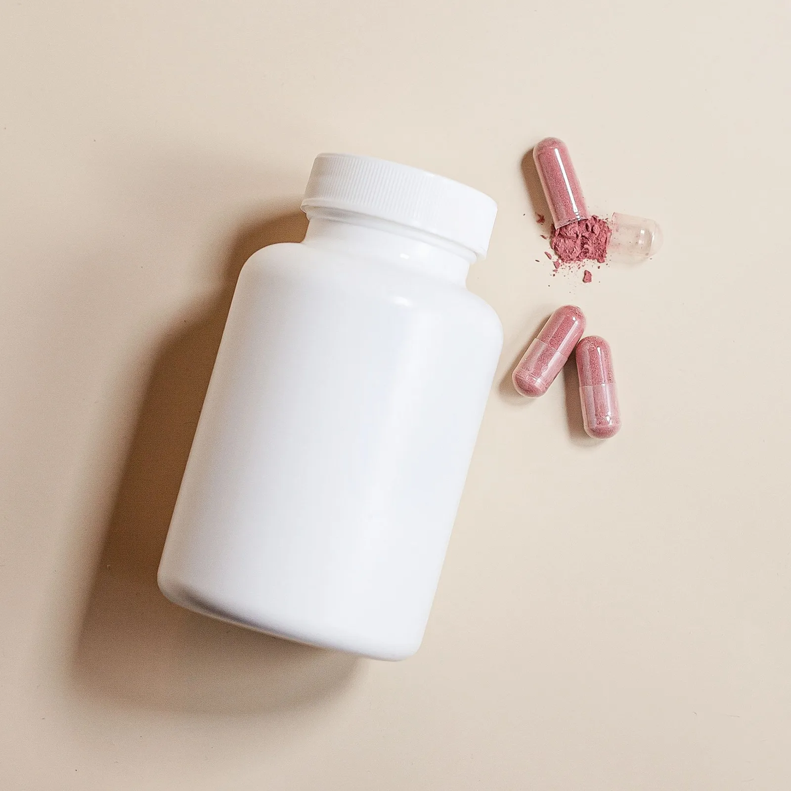 White bottle with capsules beside it