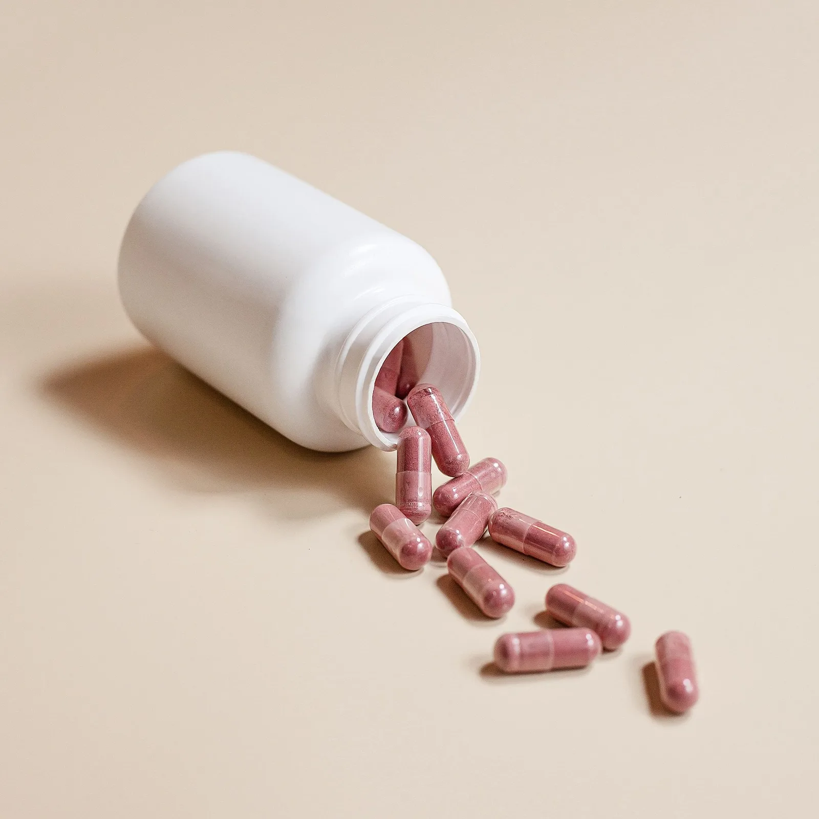 Capsules spilling from a white bottle