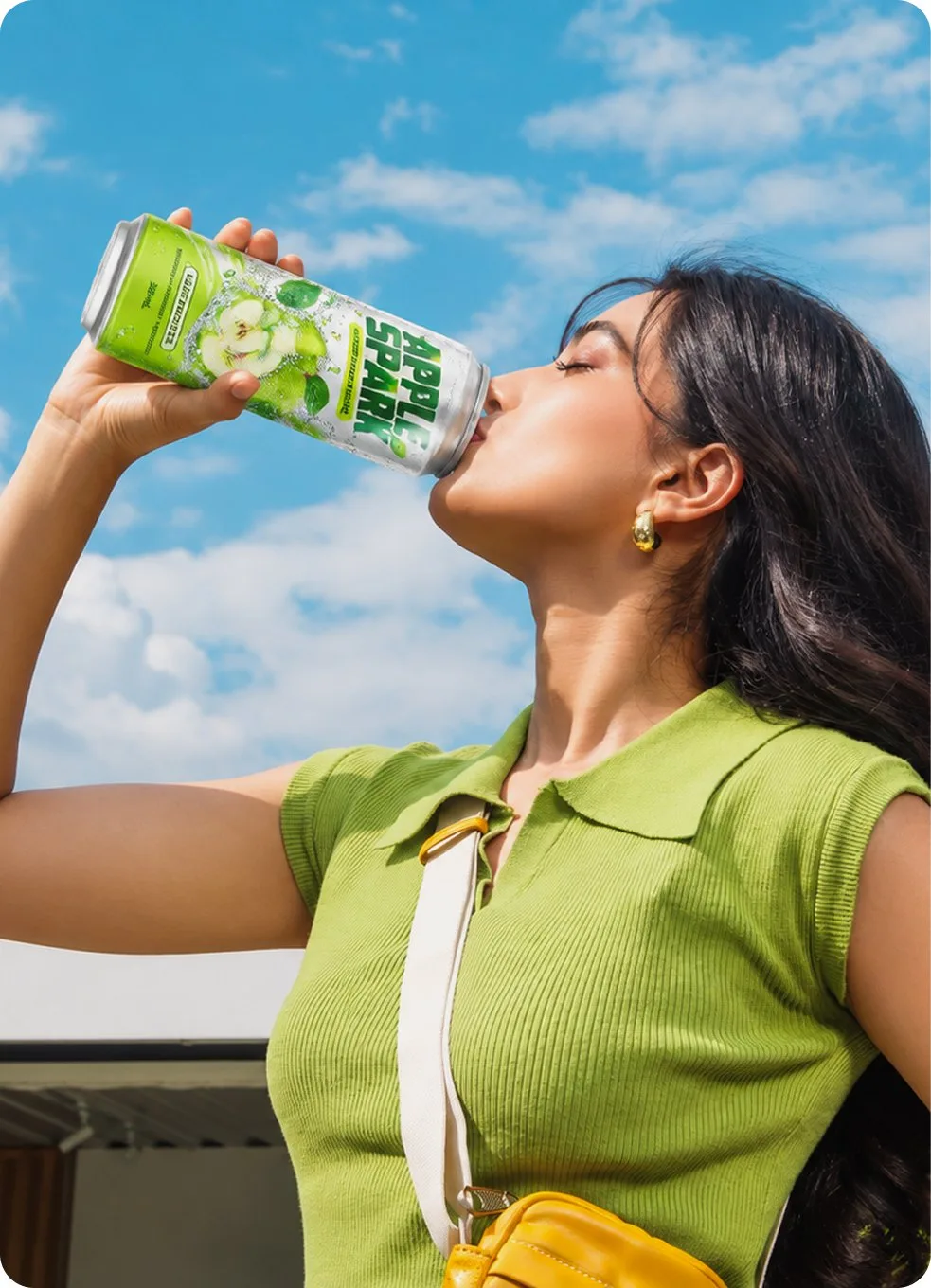 A woman drinking from a can in the sun