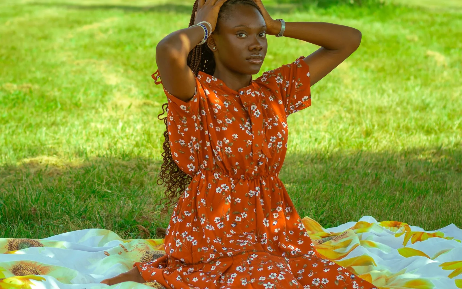 A woman in an orange dress on a picnic blanket