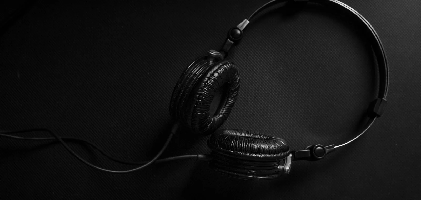 Black over-ear headphones on a dark cloth