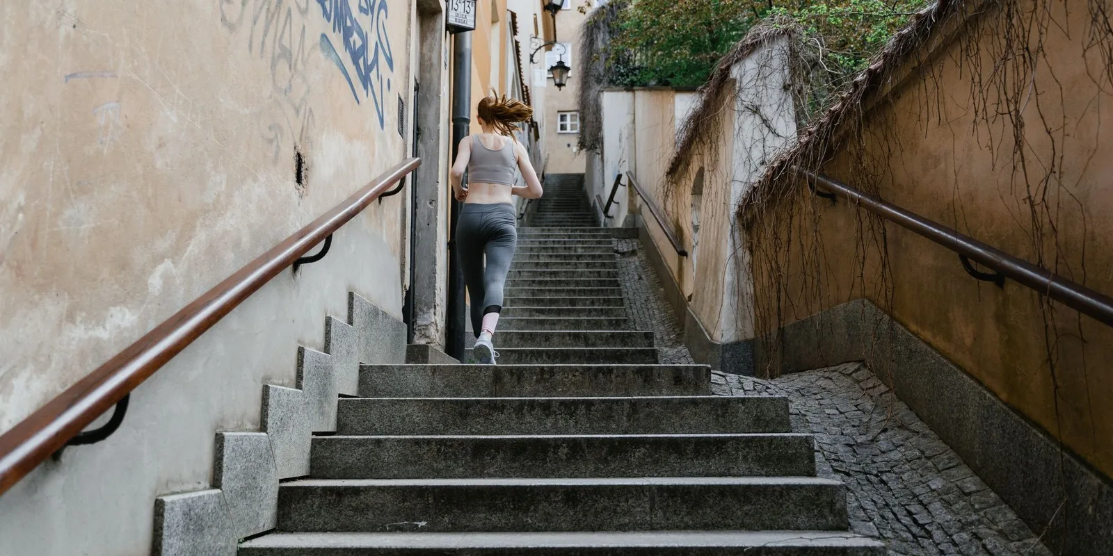 A woman running up outdoor stairs